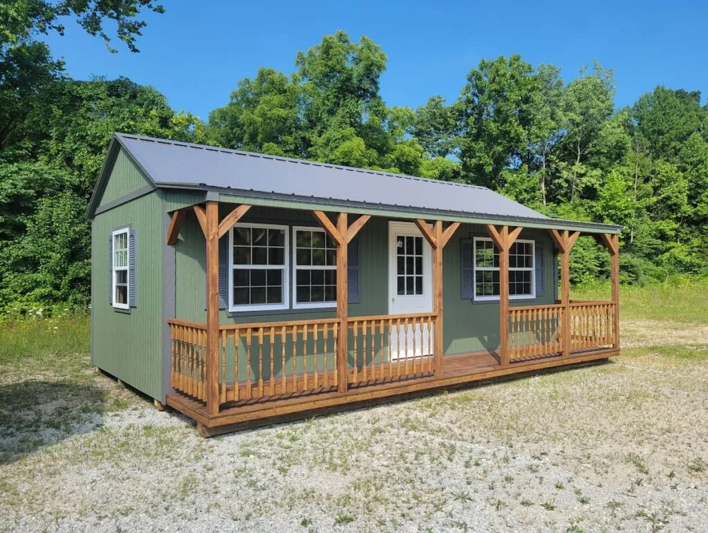 elite-lake-front-cabin-green-siding-gray-metal-roof-full-front-porch.jpg