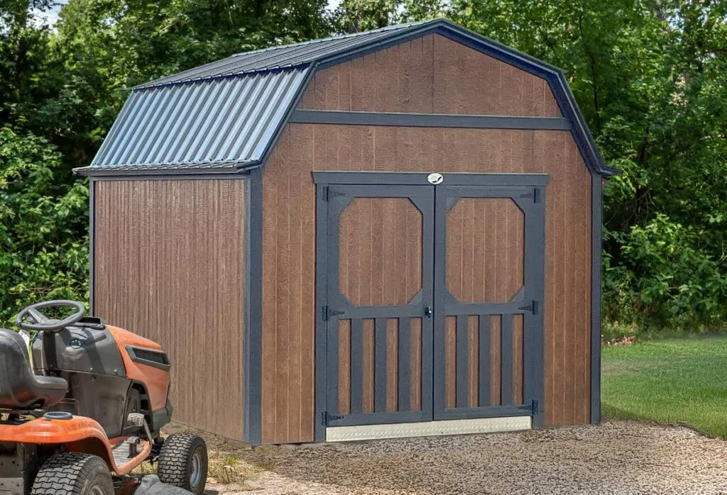 Brown Elite Lofted Barn with black trim and double doors beside a gravel drive