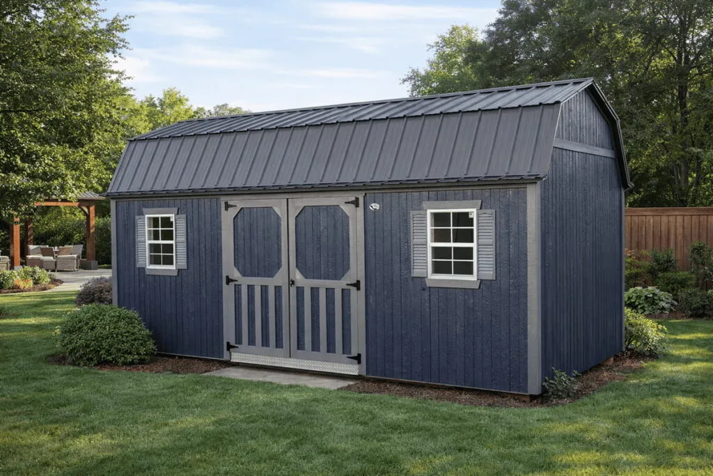 Blue Elite Lofted Garden Barn with gray trim, double doors, and two front windows in a landscaped backyard