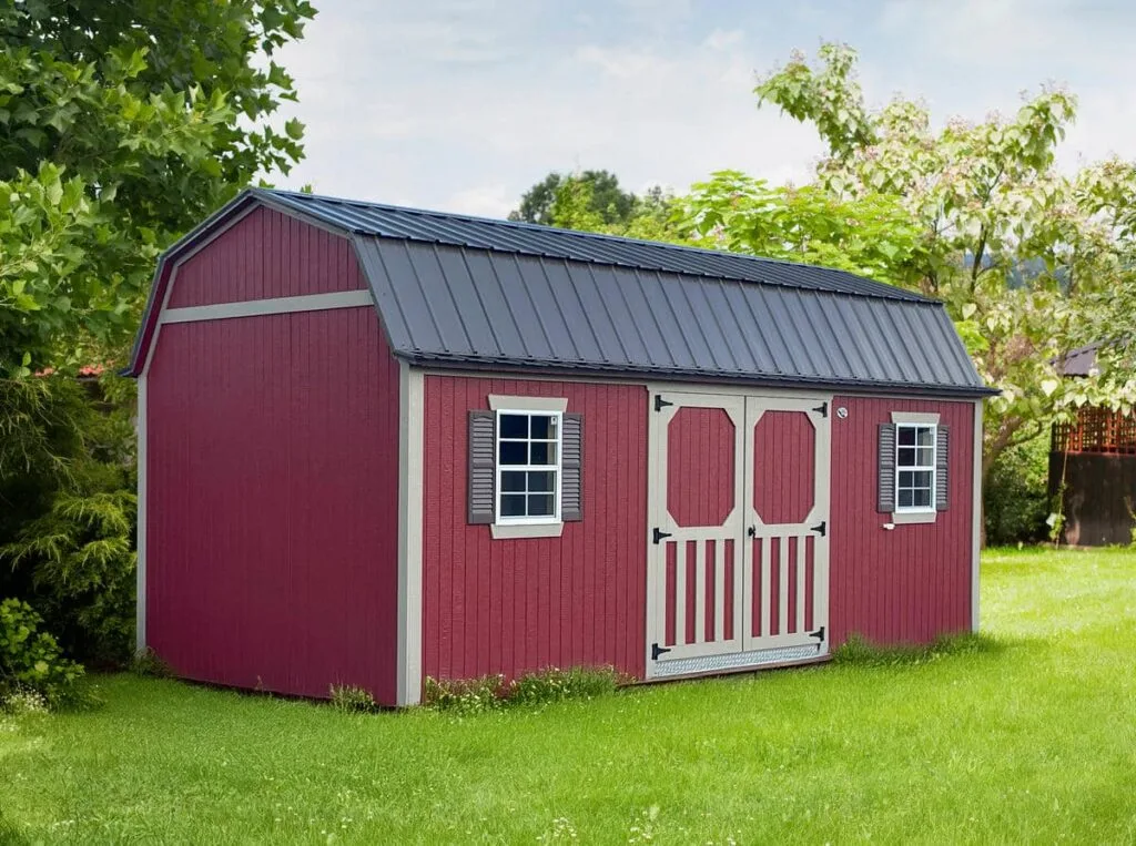 Red Elite Lofted Garden Barn with gray trim, double doors, and front windows on a grassy lot