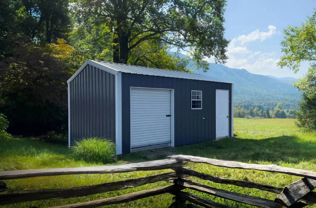 Charcoal Hoosier Classic Shed with white trim, roll-up garage door, side entry door, and window in a grassy mountain setting